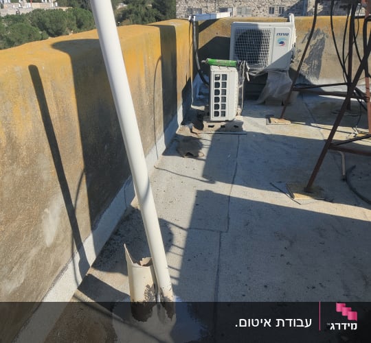 צינור אטום בחומר לבן על גג בטון